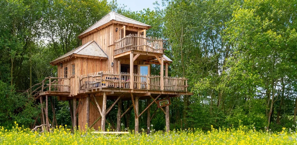 Luxuriöses Baumhaus auf Stelzen zwischen den Bäumen auf einem Campingplatz in Drenthe